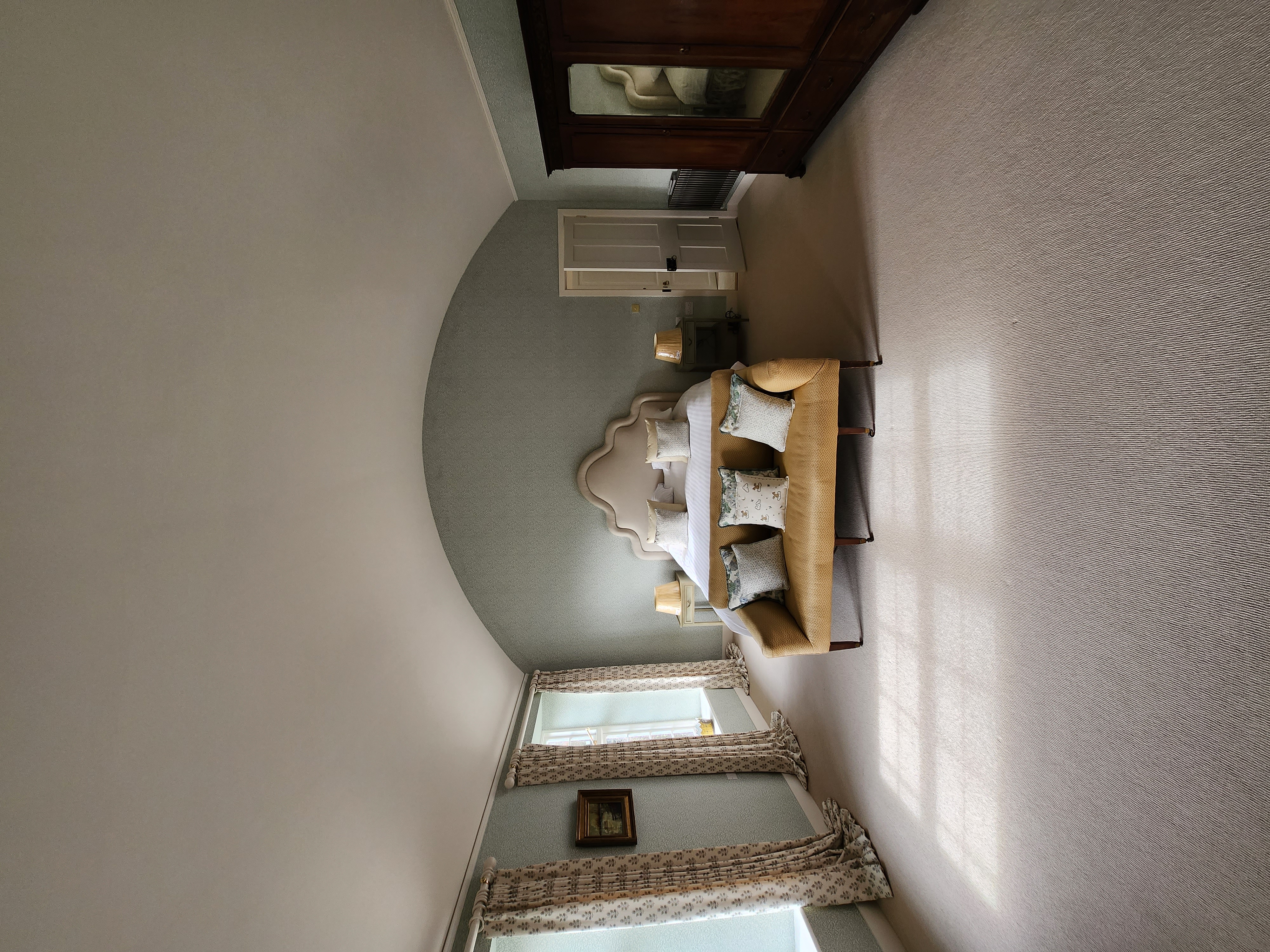 Bedroom with sage green arched alcove and herringbone wallpaper