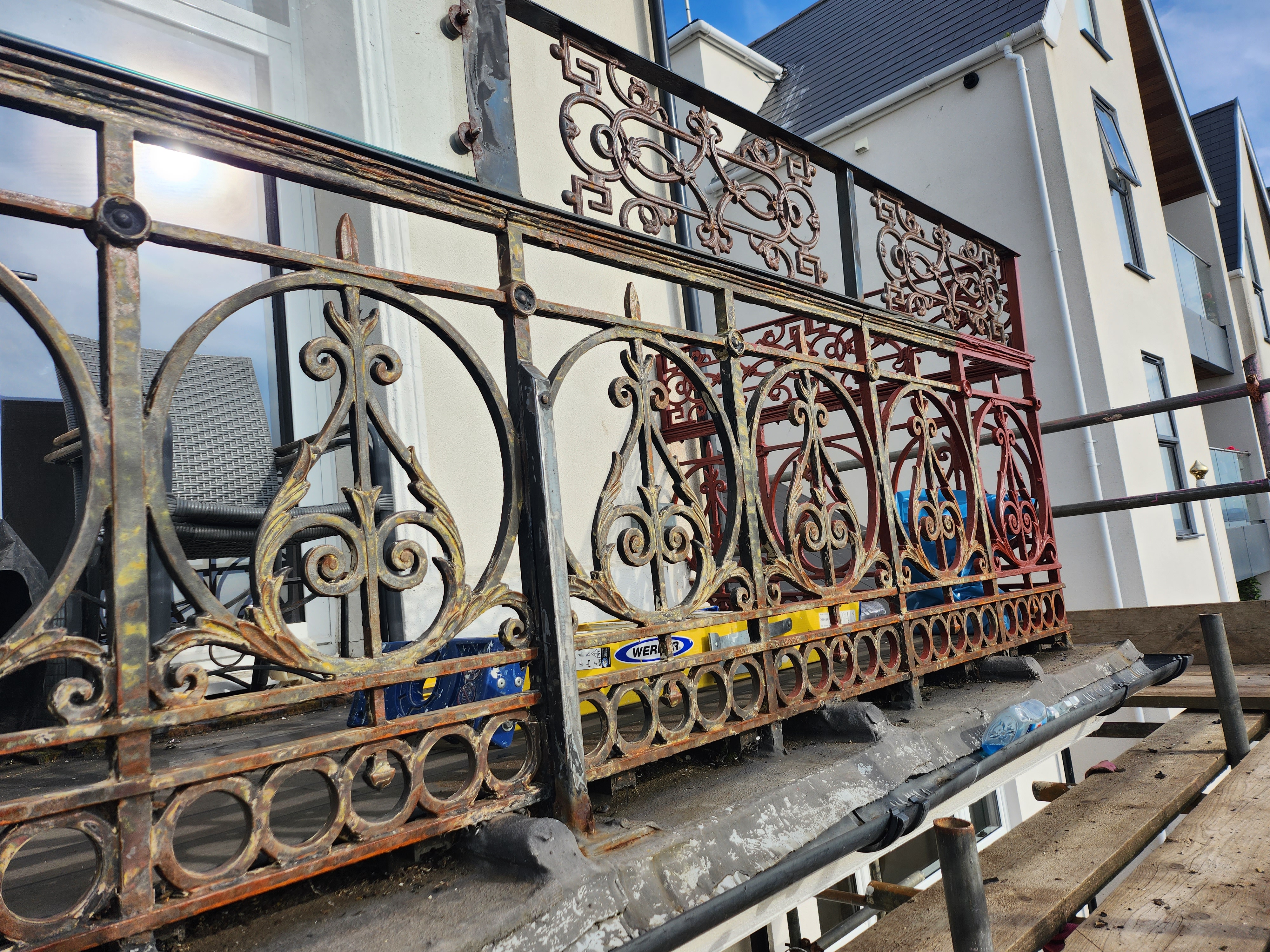 Ornate seafront iron railings before restoration — peeling and rusted