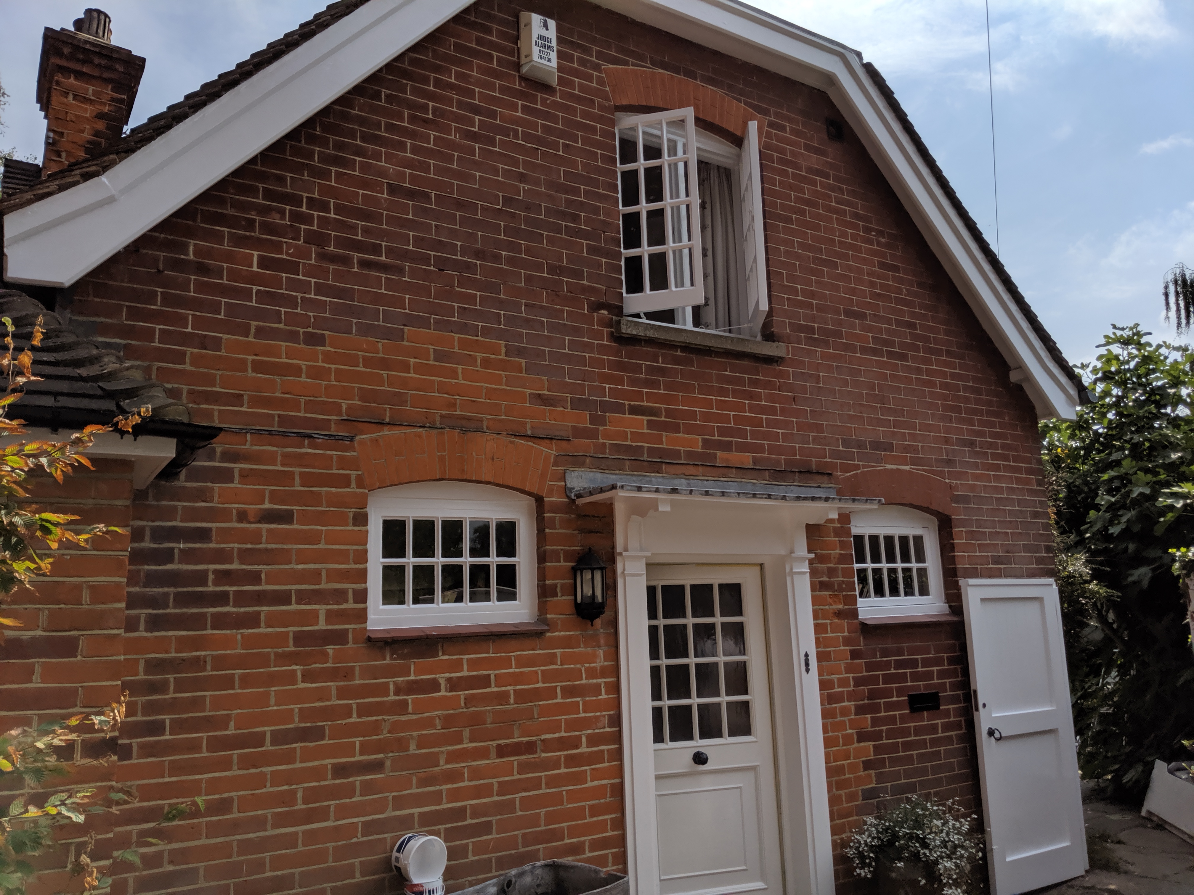 Red brick cottage with freshly painted white windows and door