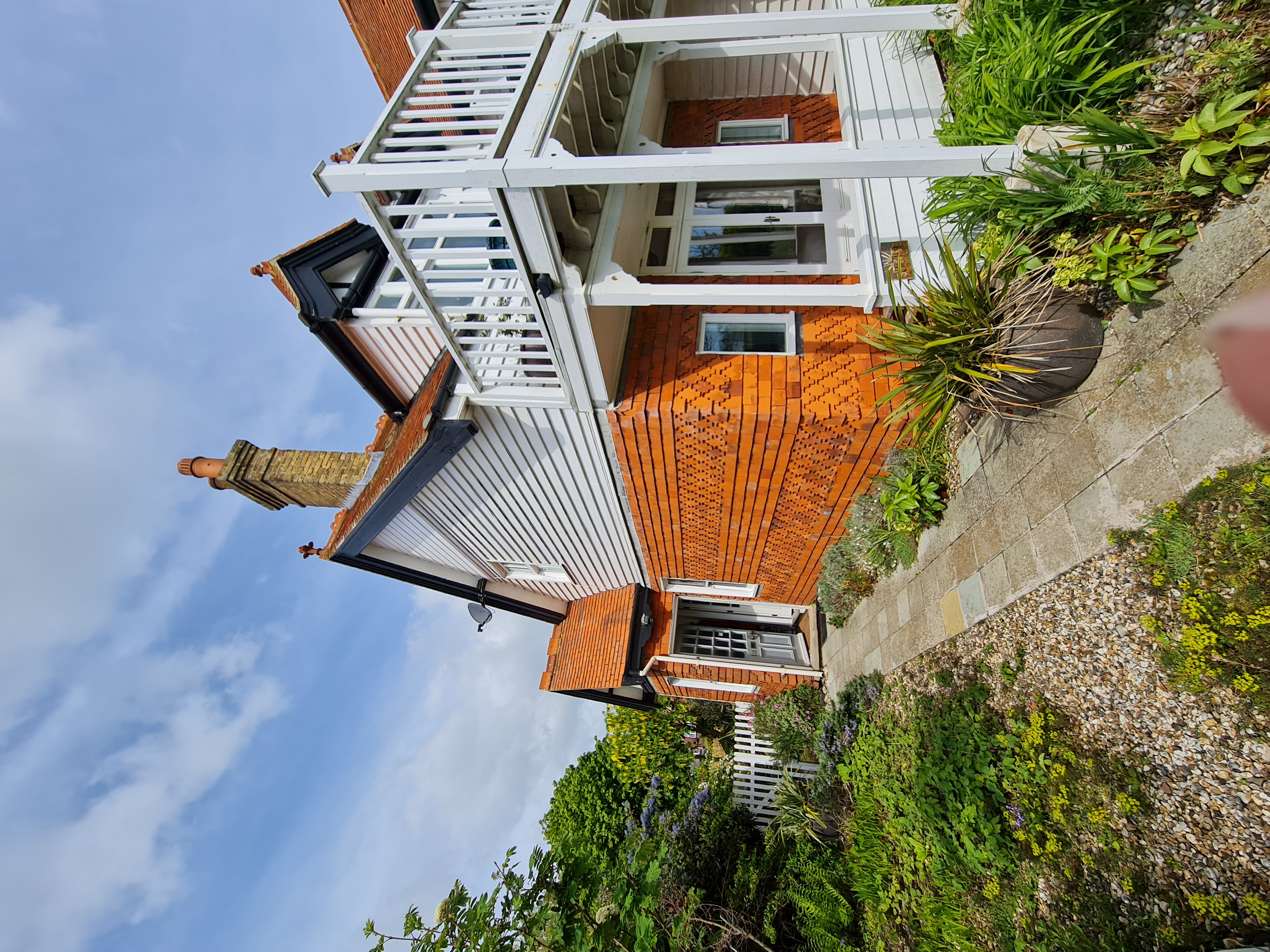 Coastal weatherboard property with tiled balcony and white painted timber