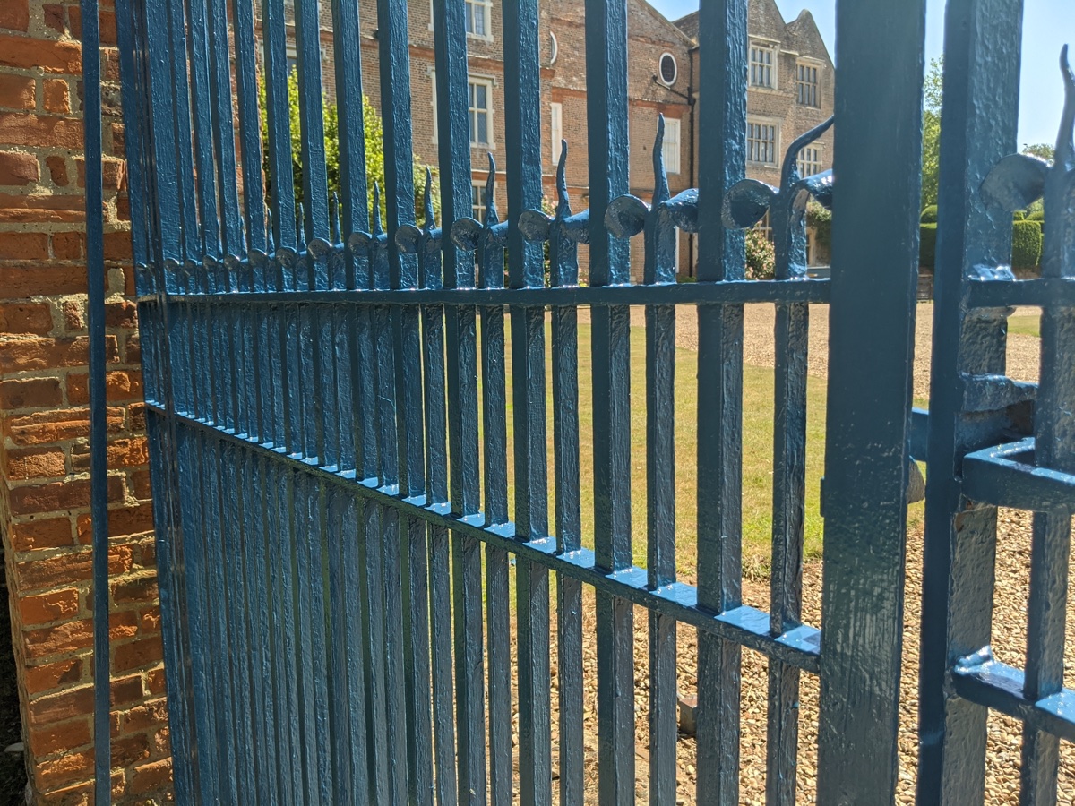 Freshly painted ornate estate entrance gates in black gloss