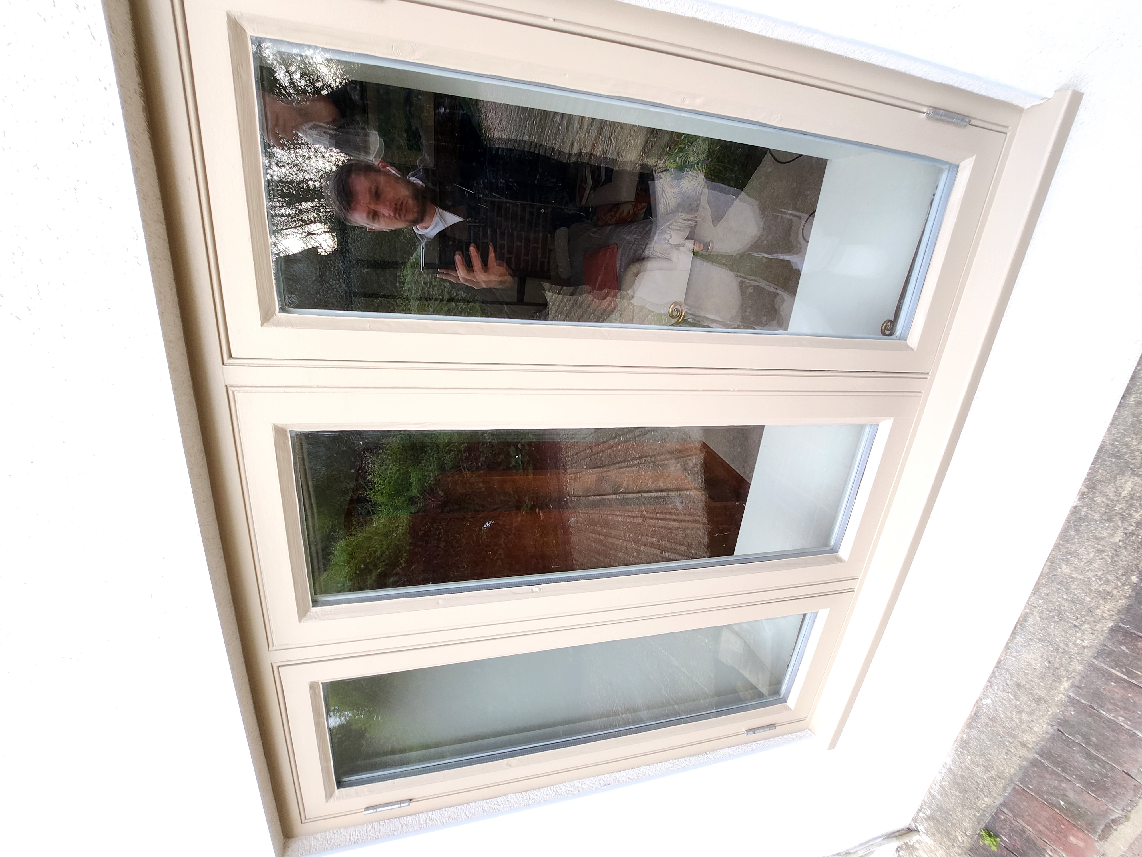 Exterior French doors painted cream with garden reflection