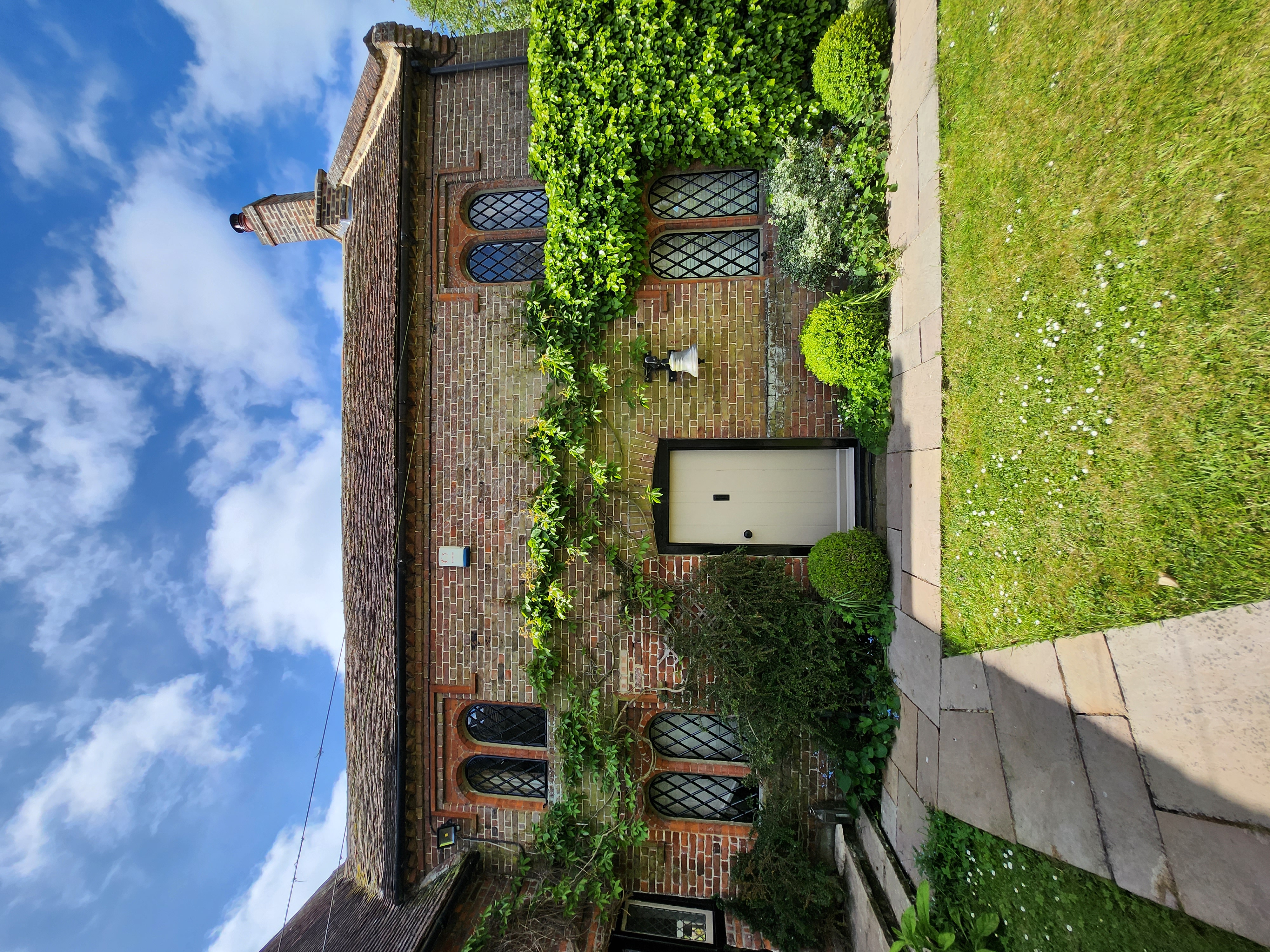 Period ivy-clad cottage with freshly painted cream front door and leaded windows