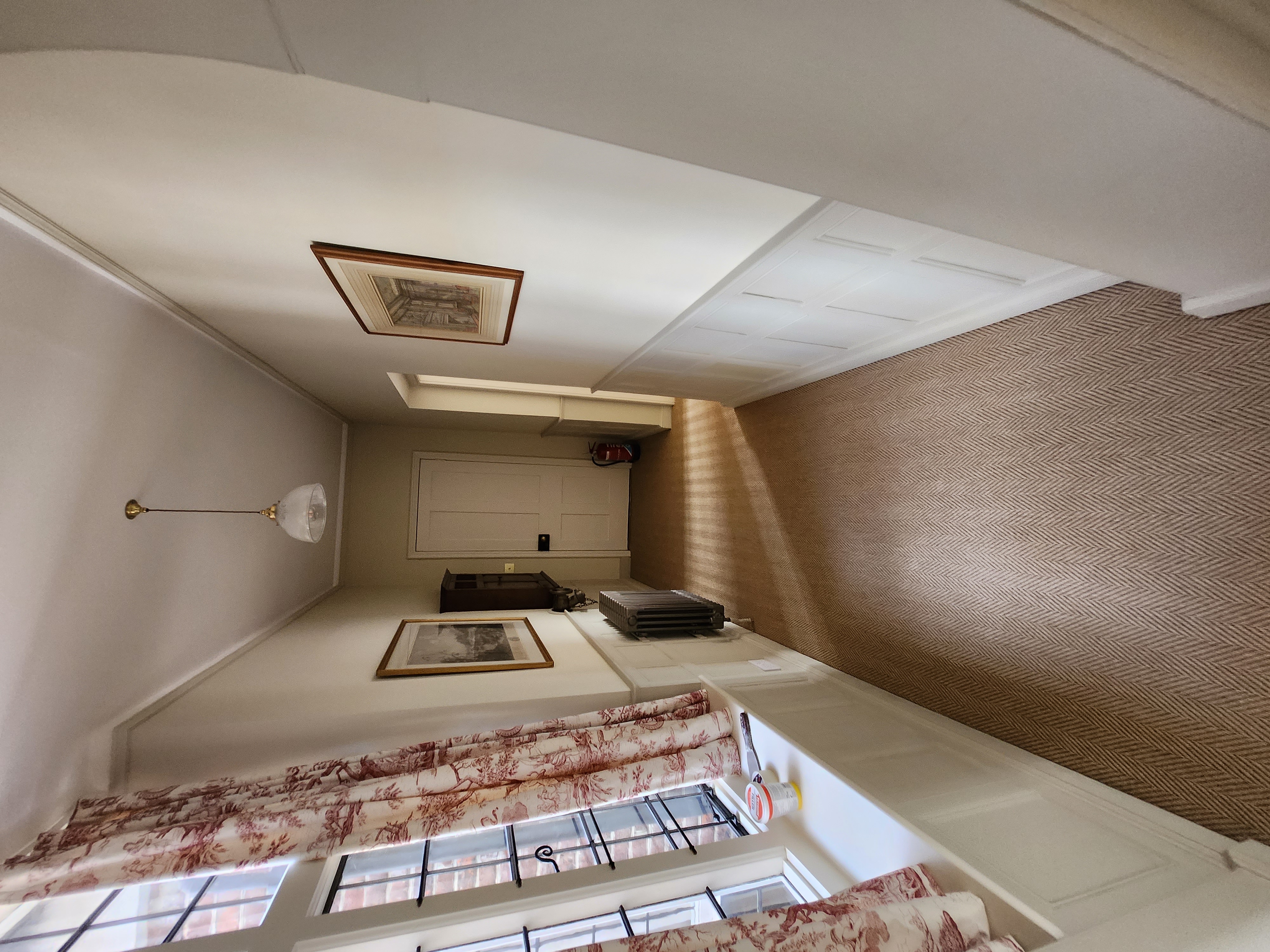 Hallway with herringbone wallpaper, white ceiling and sash window