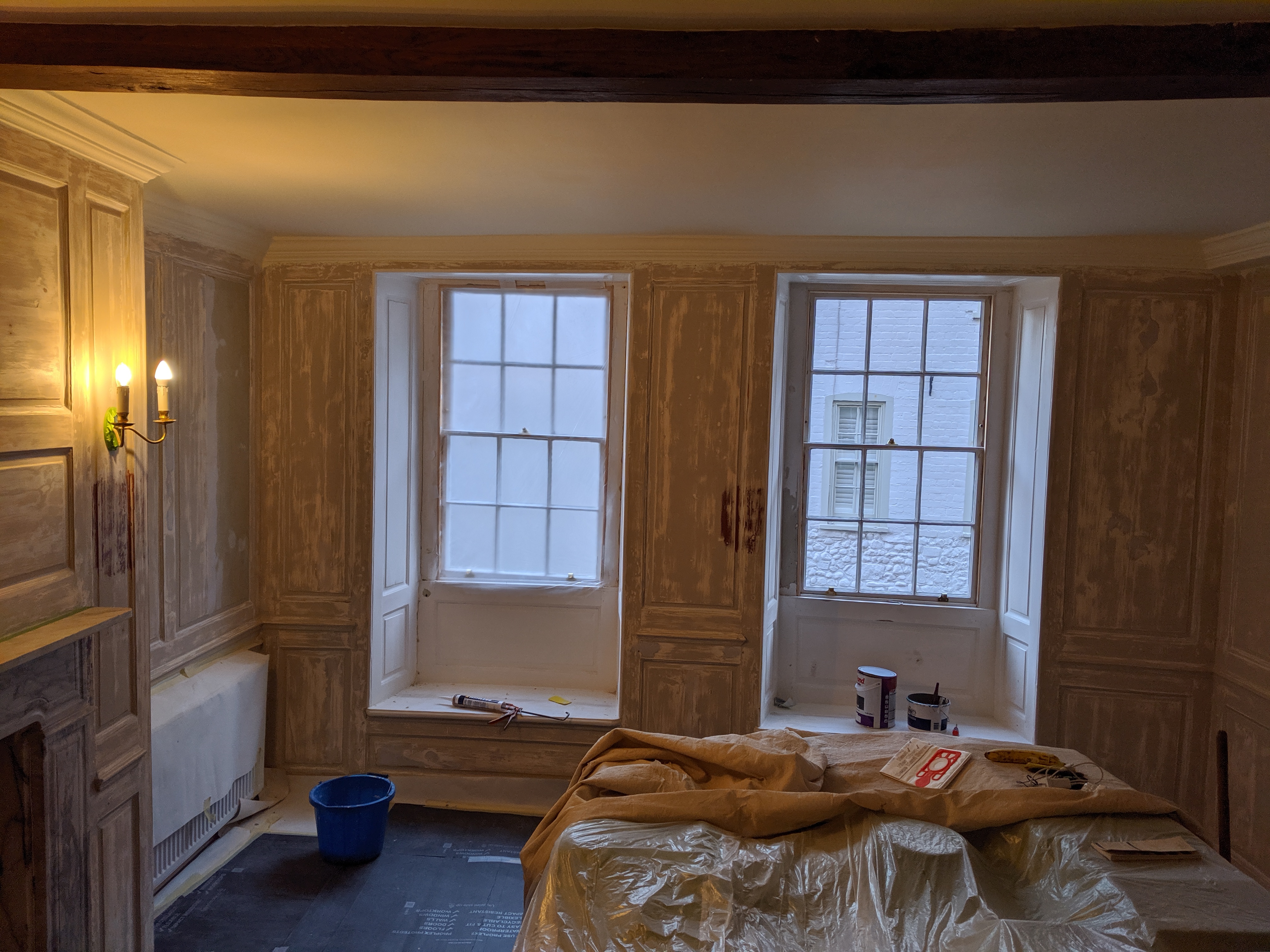 Period panelled room with two sash windows during strip-out preparation
