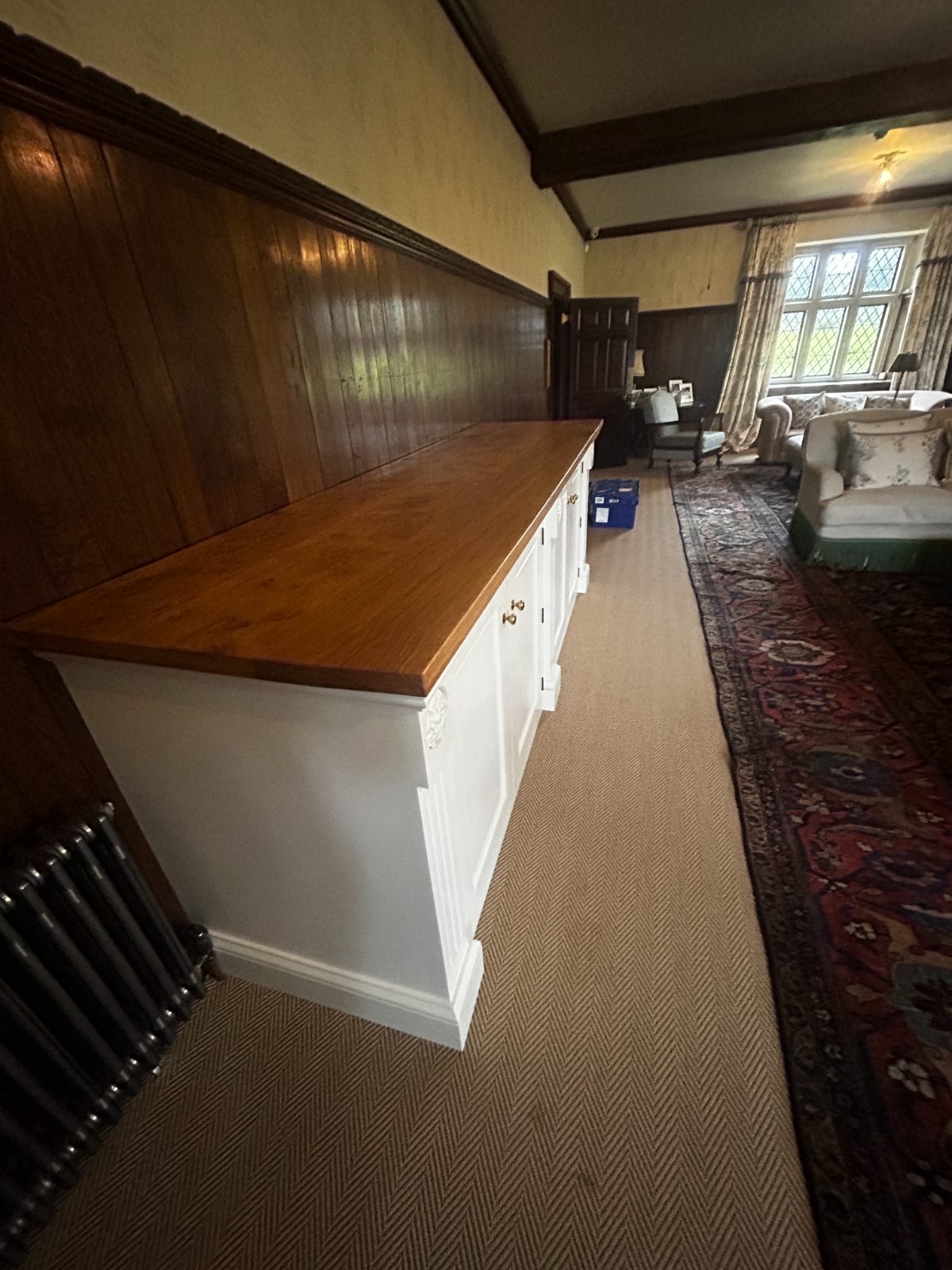 White hand-painted dresser with oiled oak top against oak panelled wall
