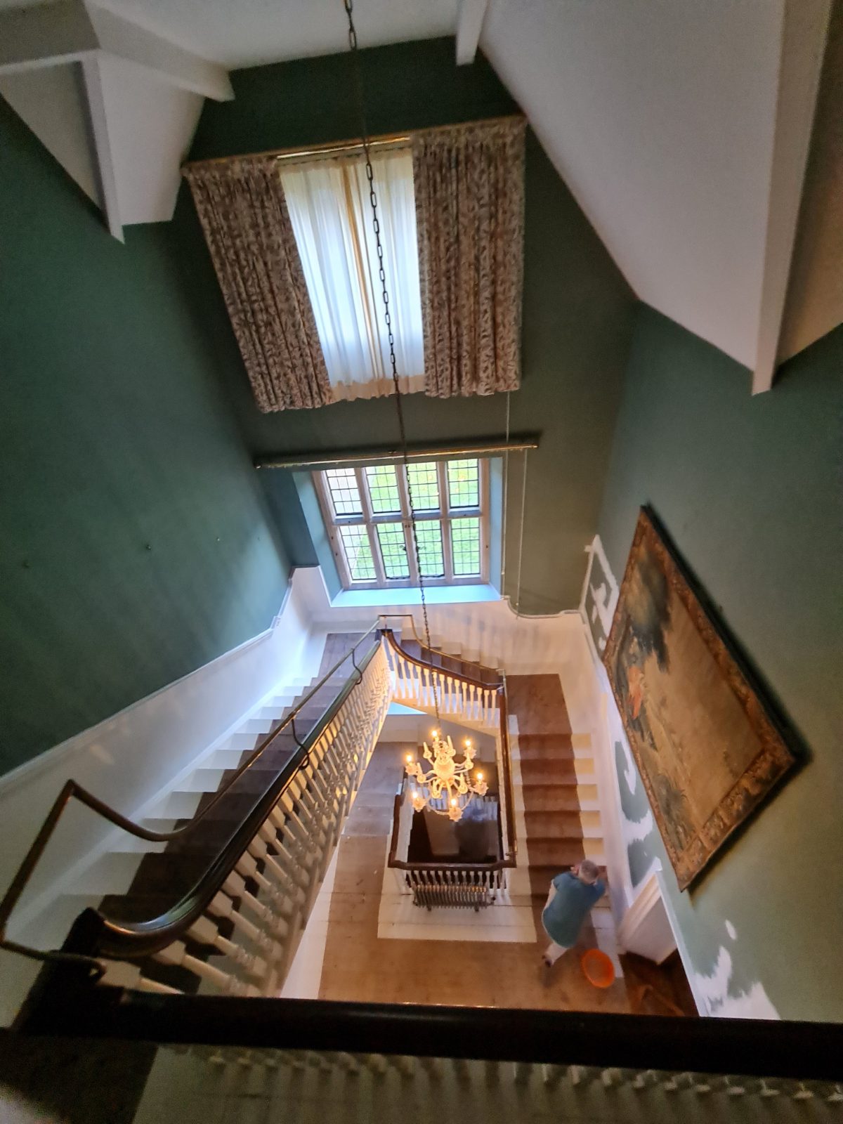 Grand manor staircase viewed from above, heritage green and white
